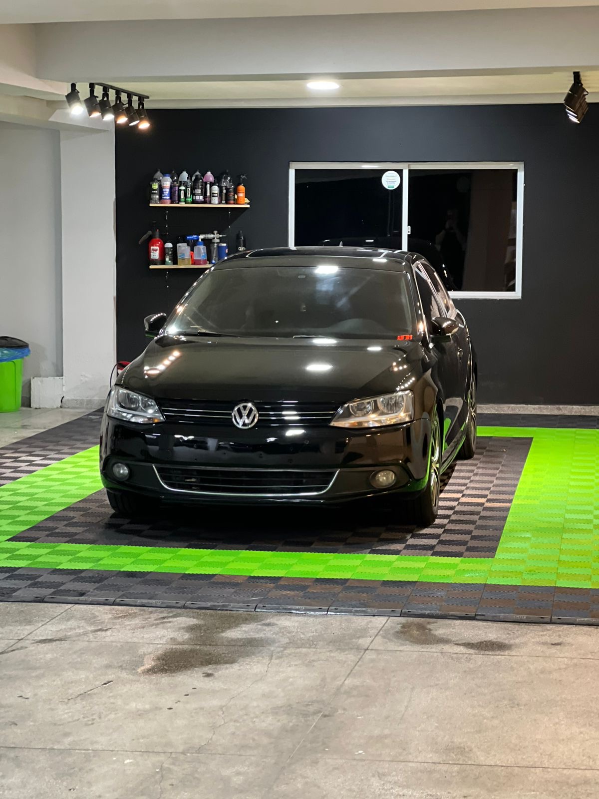 Volkswagen Jetta preto sobre piso emborrachado preto e verde da StudioF7