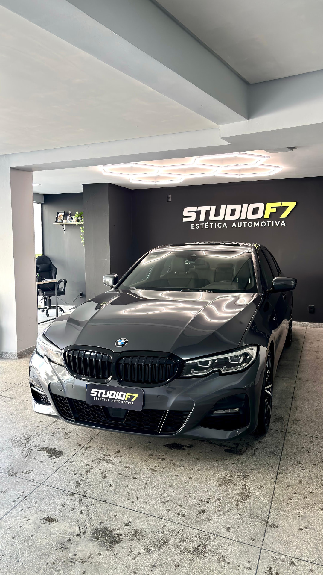 BMW cinza escuro no estúdio da StudioF7 sob luminária hexagonal
