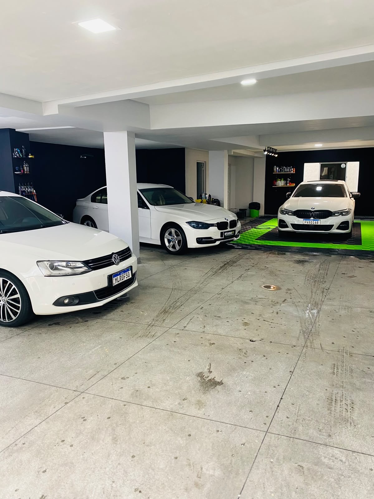 Garagem da StudioF7 com três carros brancos em atendimento